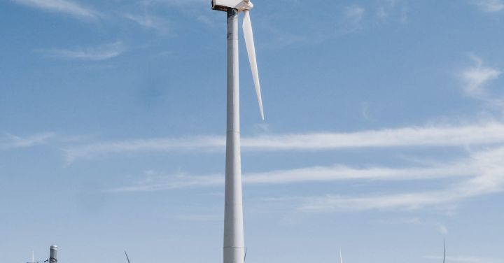Sustainable Tech - Wind Turbines on Brown Field with Fence