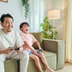 Gaming - a person and a child sitting on a couch