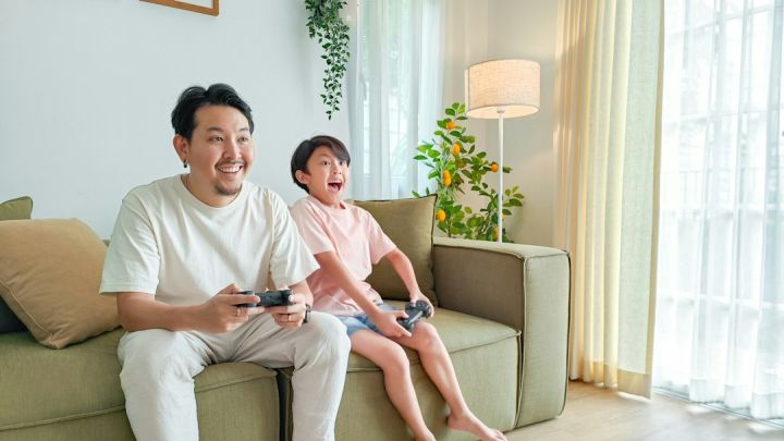 Gaming - a person and a child sitting on a couch