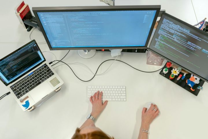 Computing - person using macbook pro on white table