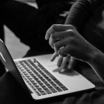 Computing - grayscale photo of person using MacBook